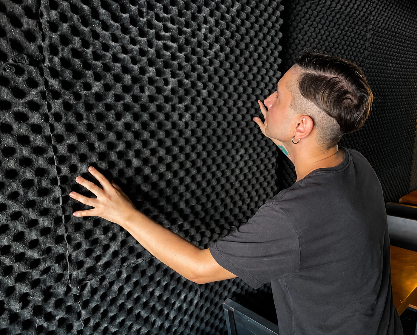 Person touching acoustic foam wall in studio