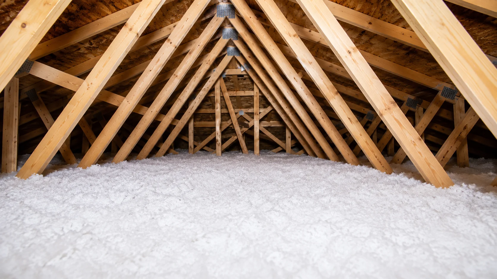 Spacious attic with wooden beams and insulation