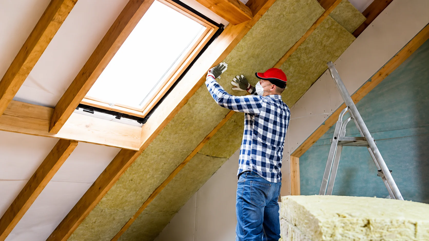 Man installing skylight in attic